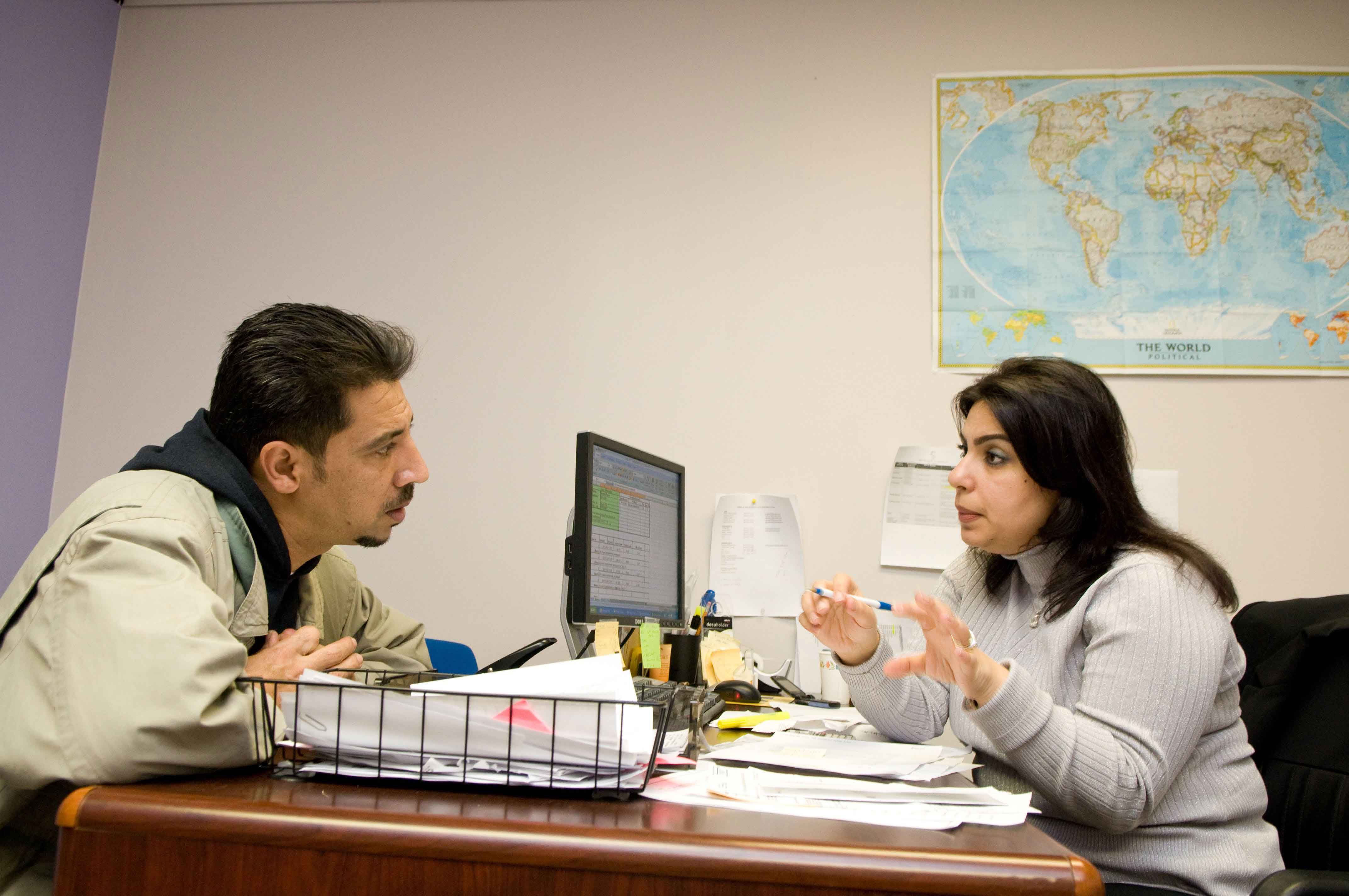 A resettlement case worker helping a refugee learn about life in the U.S.