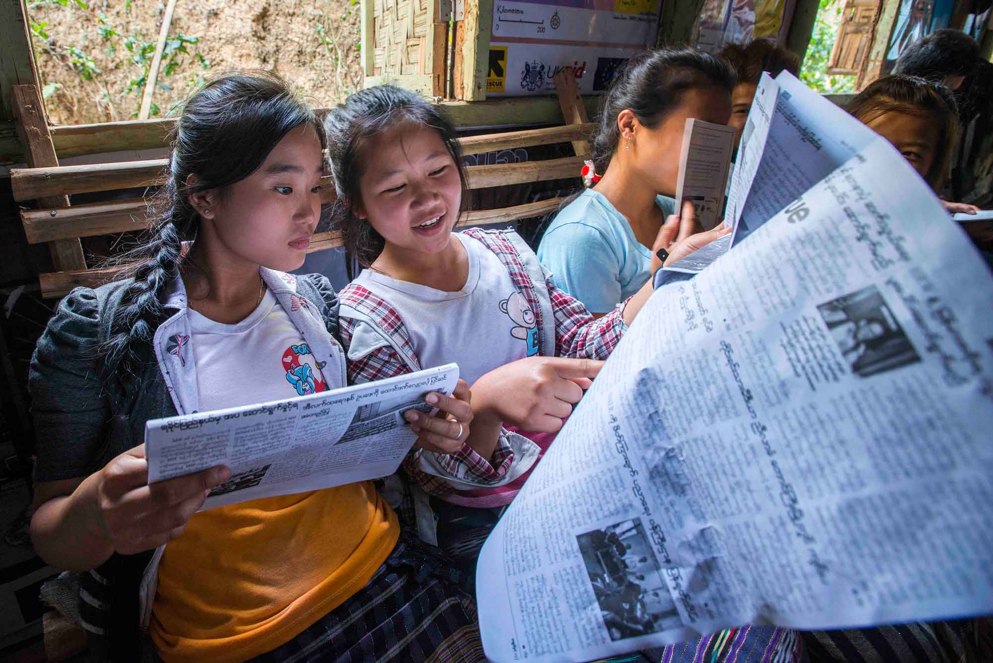 Burmese refugee young women reading the news at an IRC resource center in Myanmar