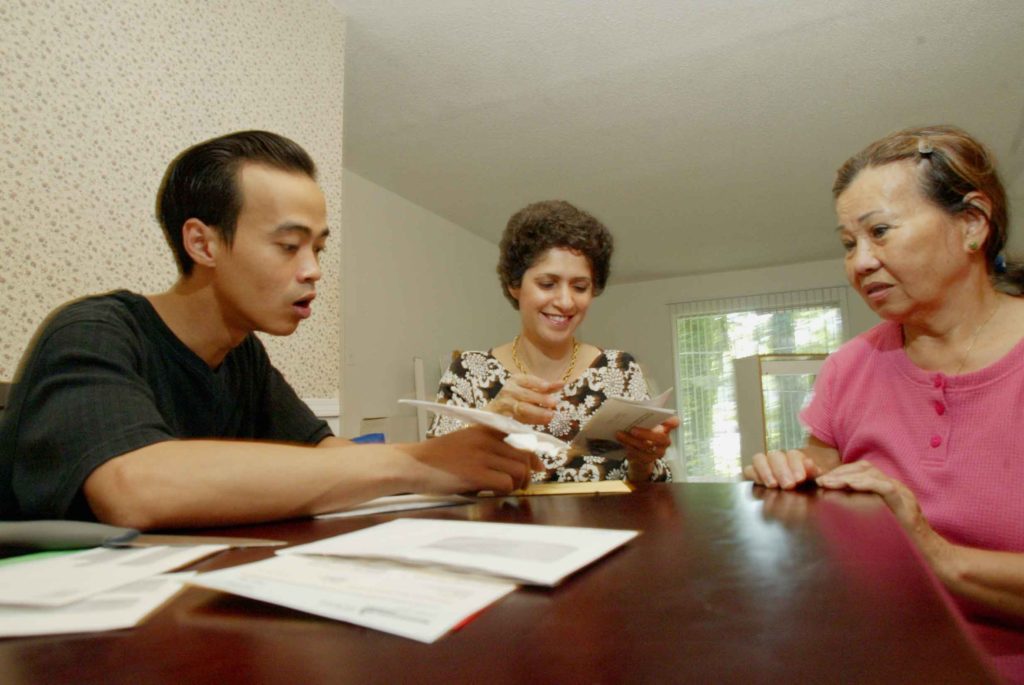 A cultural orientation trainer helping two refugees become acquainted to their new home after evacuating from Hurricane Katrina