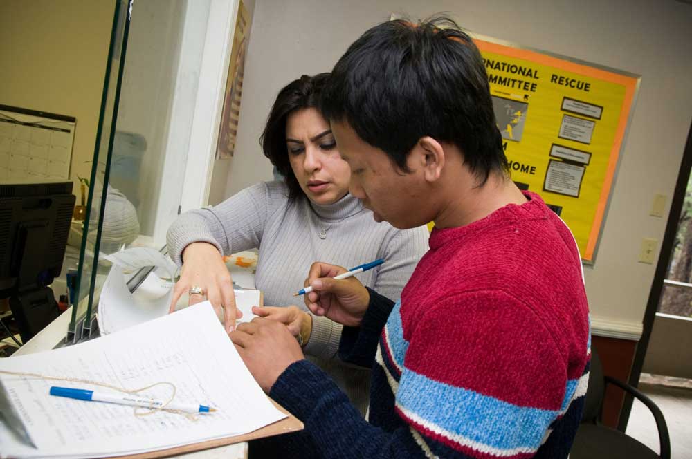 An IRC case worker helping a client with their paperwork. IRC/Manuel Llaneras