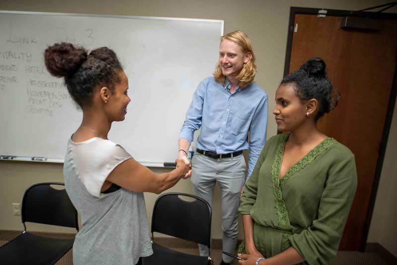 Refugees attend a hospitality link class, teaching them common industry vocabulary and American styles of greeting