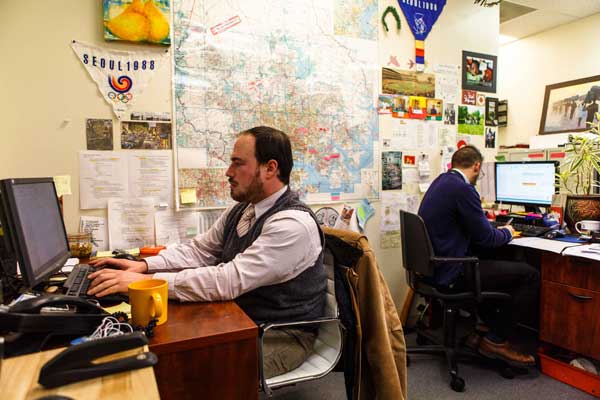Two refugee resettlement staff workers at their desk in the Baltimore office