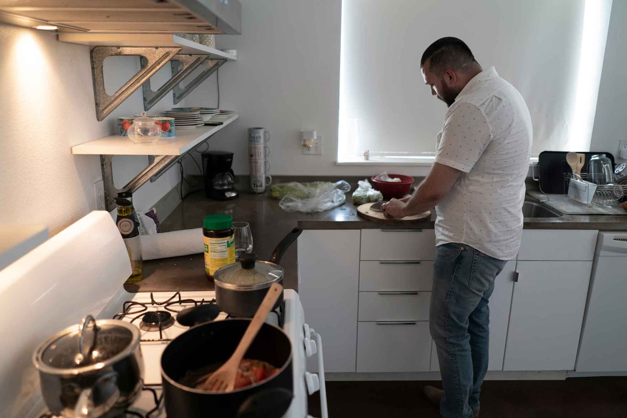 A Central American refugee cooking in his home