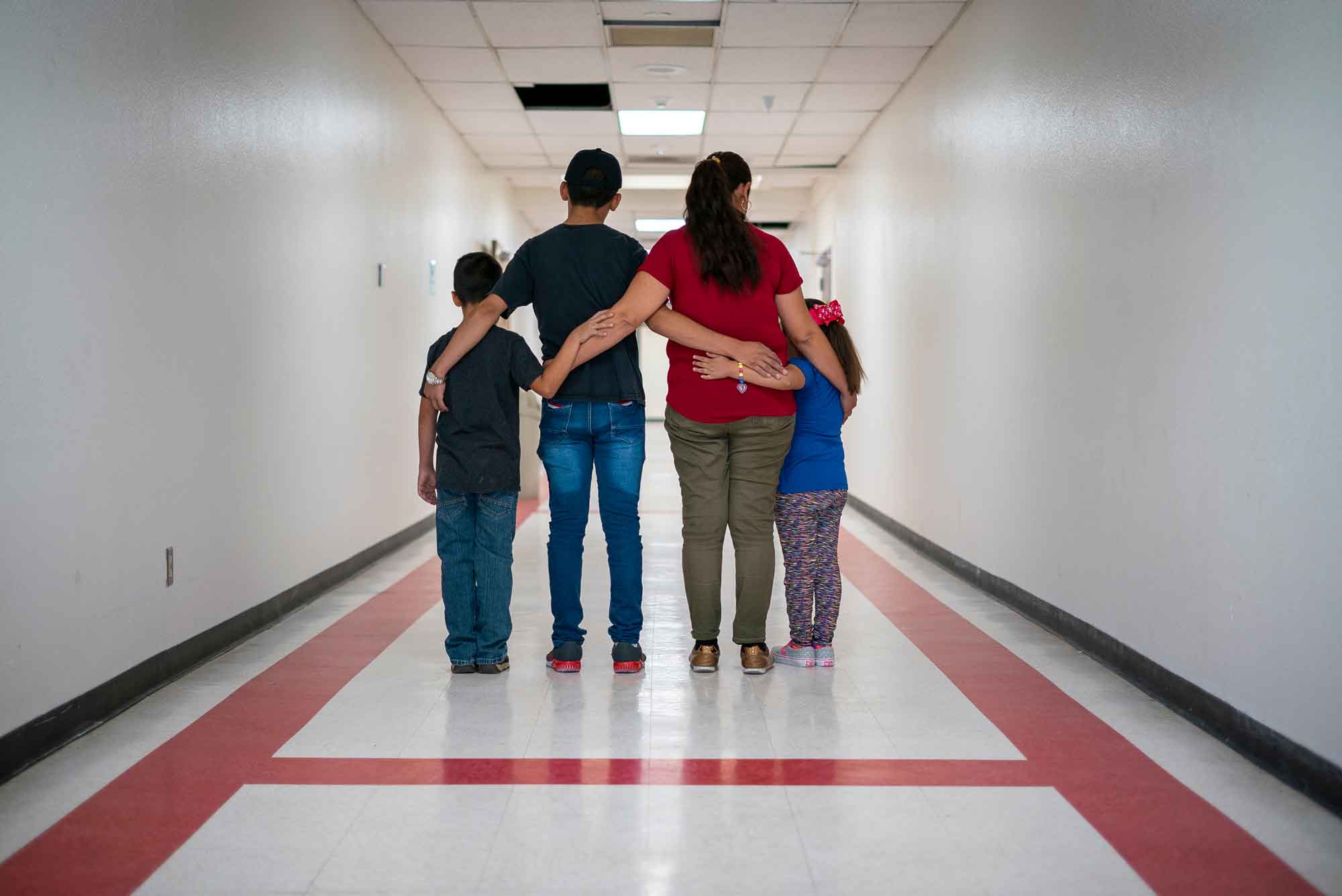 A refugee family standing together, arm in arm, at the airport