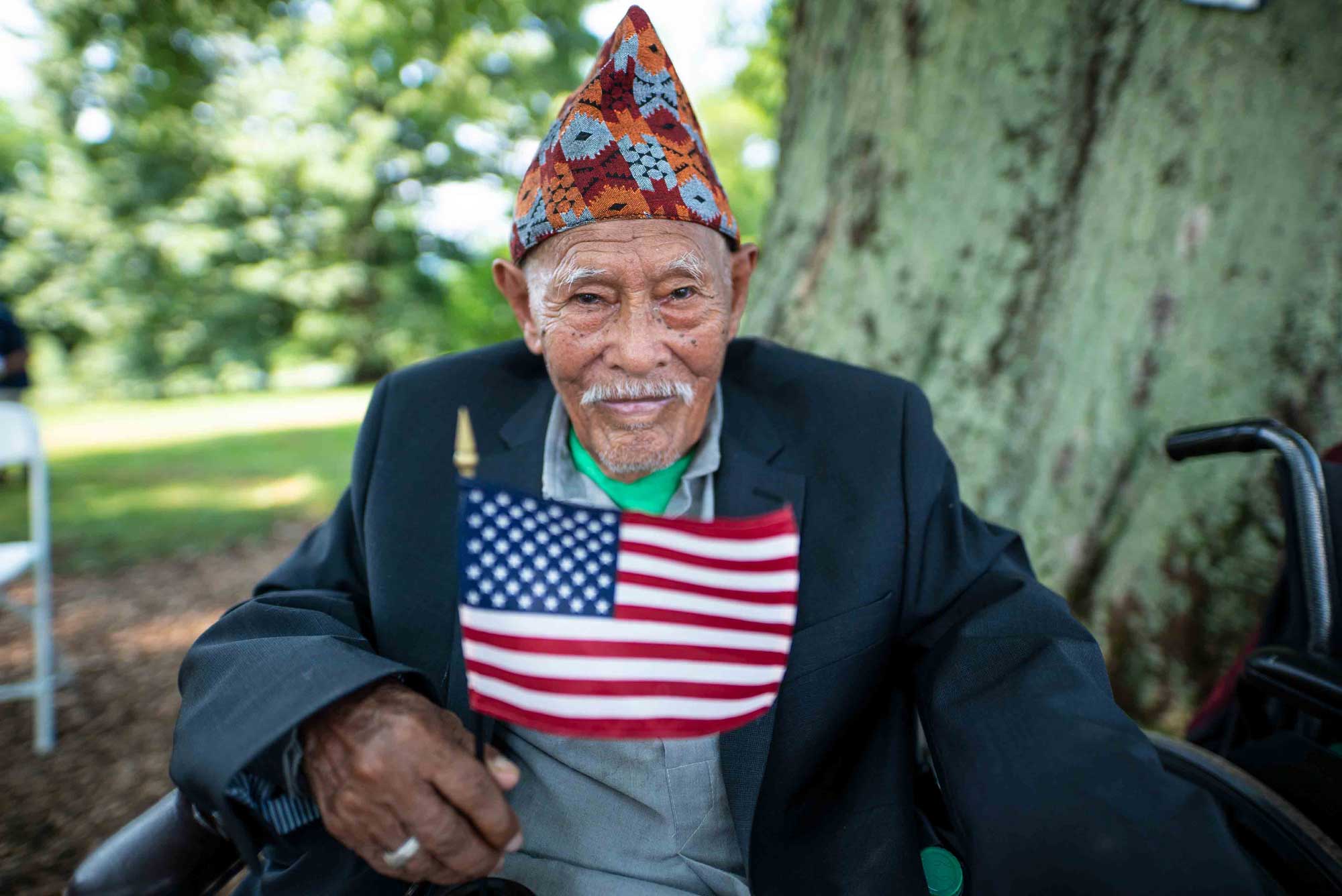 A recently naturalized refugee holding an American flag. IRC/Andrew Oberstadt