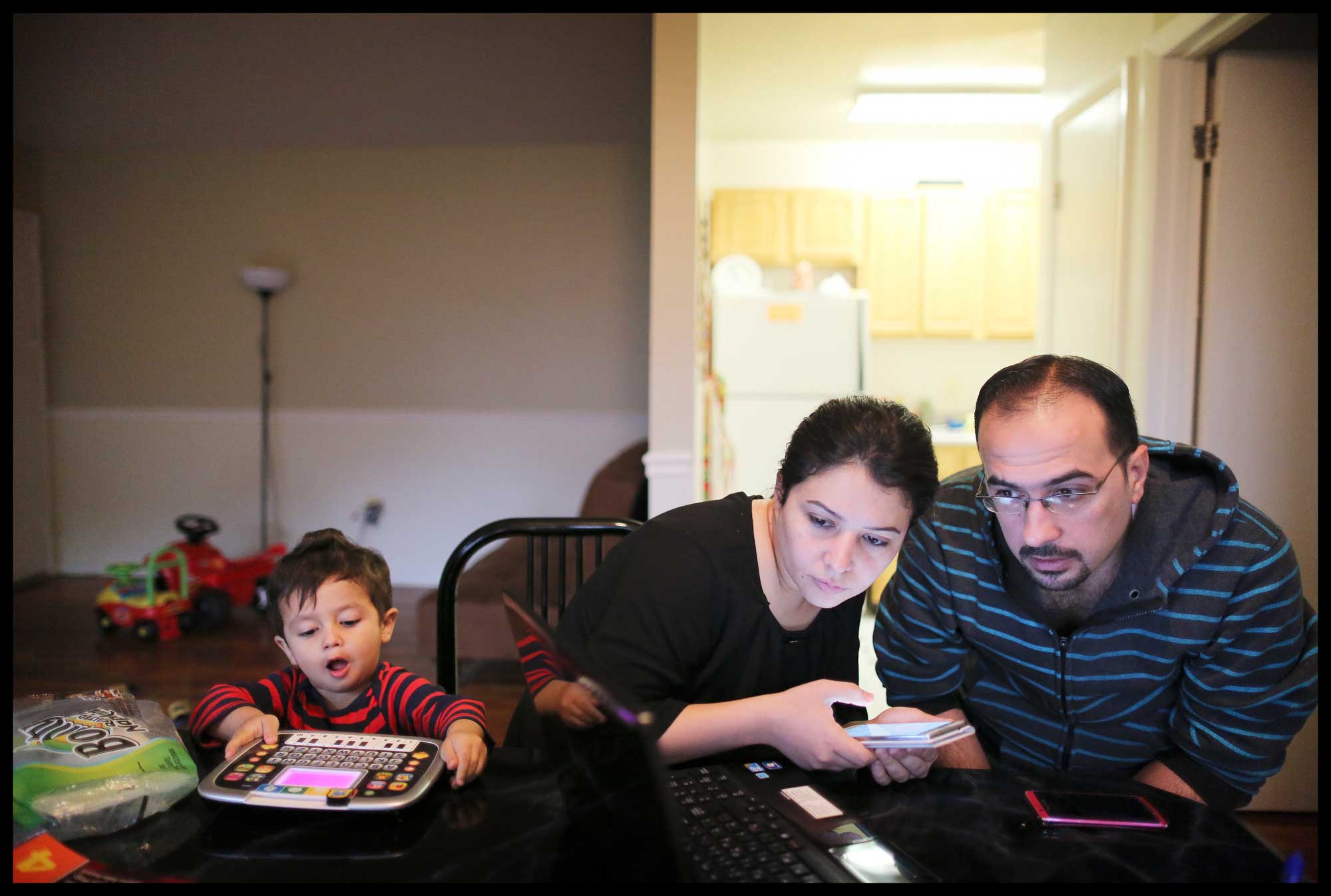 A refugee family working on job applications online. IRC/CBibby