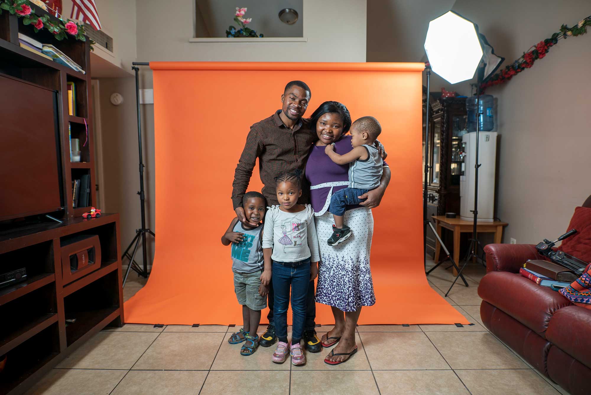 Portrait of a refugee family standing in their home. IRC/AOberstadt