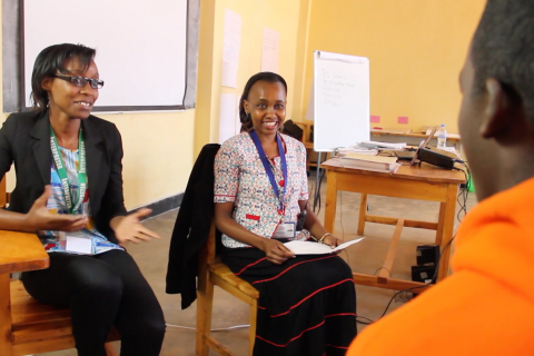 Two women resettlement staff members talking with a man